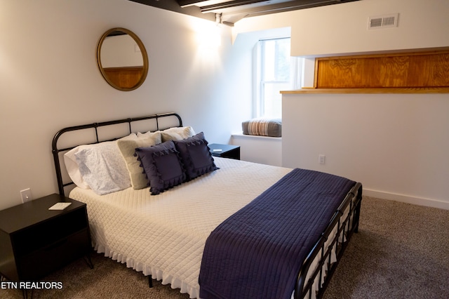 carpeted bedroom with beam ceiling