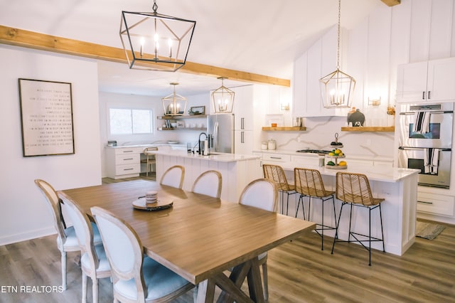 dining area with beamed ceiling, dark wood-type flooring, and a chandelier