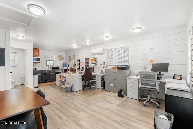 office area with a wall mounted air conditioner and light wood-type flooring