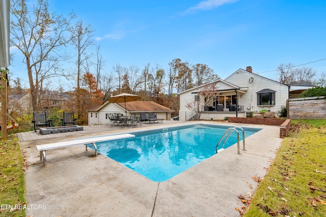 view of pool featuring a diving board and a patio