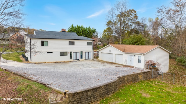 back of house with an outbuilding and a garage