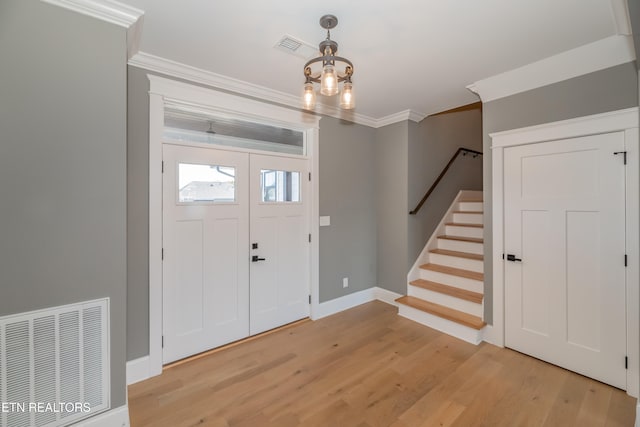 entrance foyer featuring light hardwood / wood-style floors and crown molding