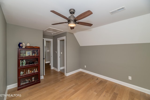 additional living space featuring light wood-type flooring and vaulted ceiling