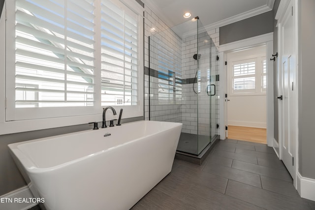 bathroom with plus walk in shower, wood-type flooring, and ornamental molding