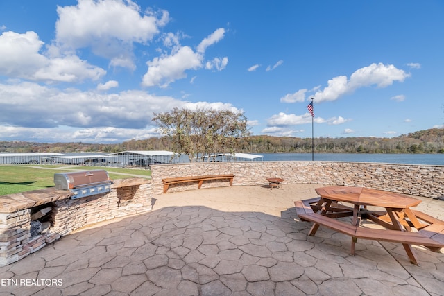 view of patio / terrace with area for grilling, a water view, and grilling area