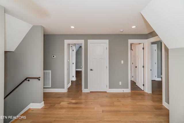 additional living space with light hardwood / wood-style flooring