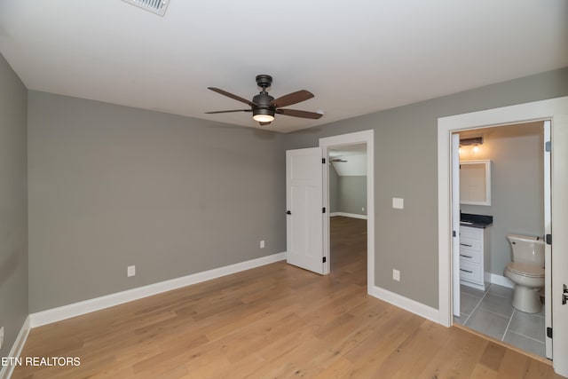 unfurnished bedroom with ceiling fan, connected bathroom, and light hardwood / wood-style flooring