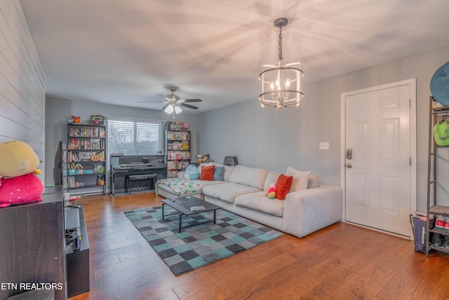 living room with hardwood / wood-style floors and ceiling fan with notable chandelier