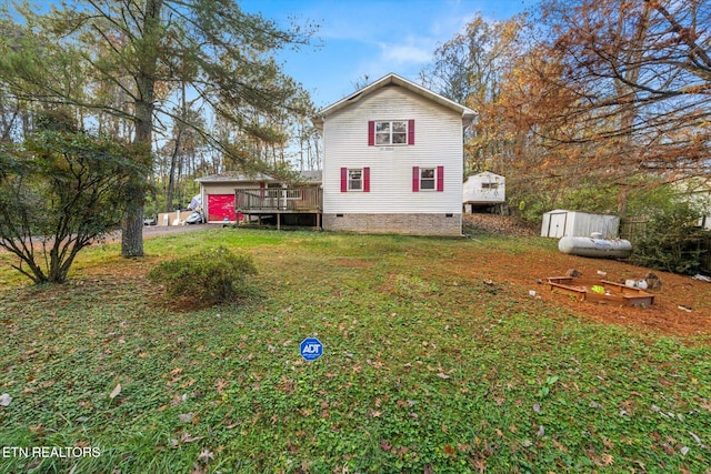 exterior space with a deck, a storage unit, and a lawn