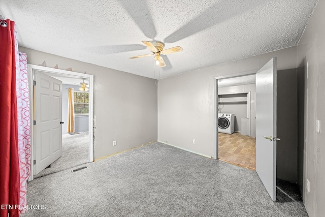 unfurnished bedroom featuring washer / clothes dryer, ceiling fan, light carpet, and a textured ceiling