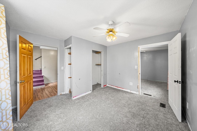 unfurnished bedroom with carpet flooring, ceiling fan, and a textured ceiling