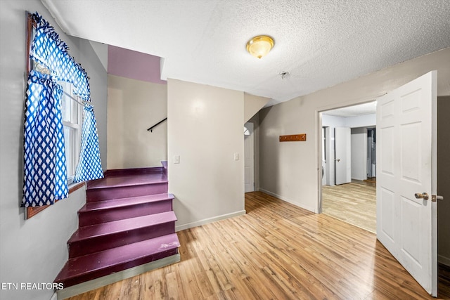 stairway with hardwood / wood-style flooring and a textured ceiling