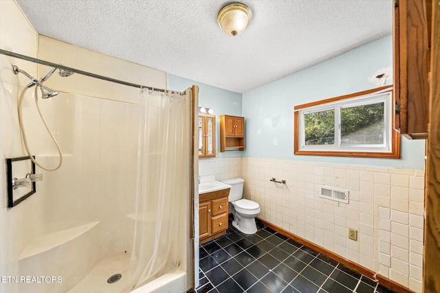 bathroom featuring a textured ceiling, vanity, tile patterned flooring, toilet, and curtained shower