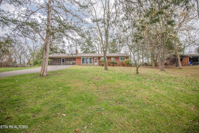 ranch-style home with a sunroom and a front yard