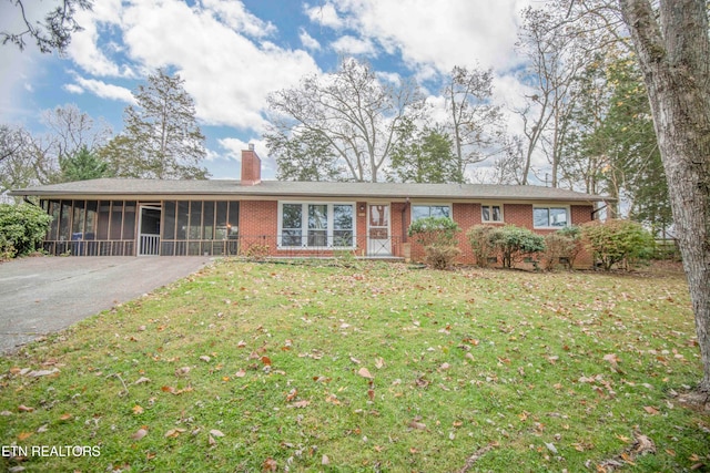 ranch-style house with a sunroom and a front lawn