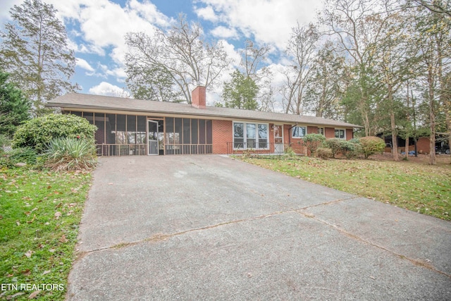 ranch-style home featuring a sunroom and a front yard