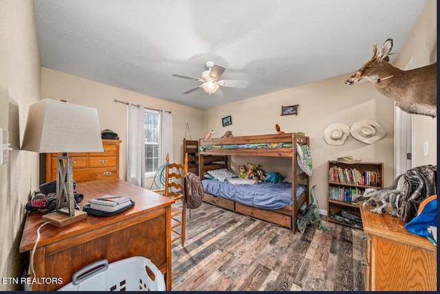 bedroom featuring ceiling fan, wood-type flooring, and a textured ceiling