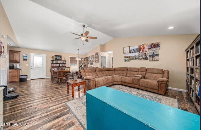 living room featuring lofted ceiling, dark wood-type flooring, and ceiling fan