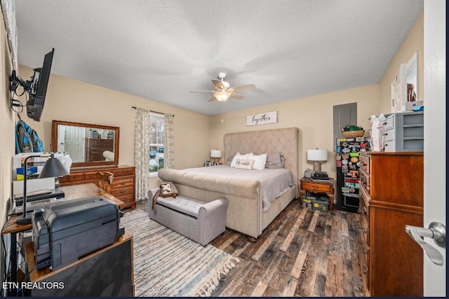 bedroom featuring dark wood-type flooring, ceiling fan, and a textured ceiling