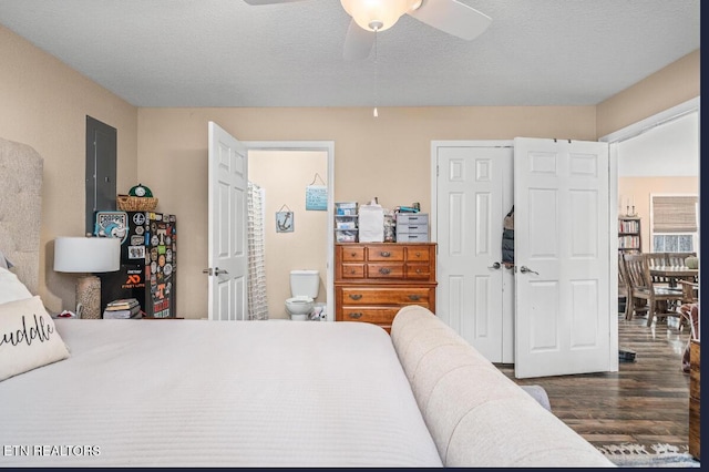 bedroom featuring dark hardwood / wood-style flooring, ensuite bath, a textured ceiling, and ceiling fan