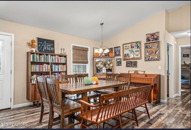 dining room featuring lofted ceiling, a chandelier, and dark hardwood / wood-style flooring