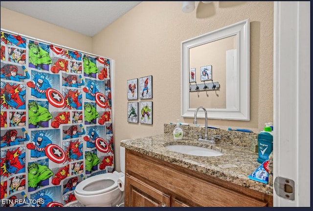 bathroom featuring vanity, toilet, and a textured ceiling