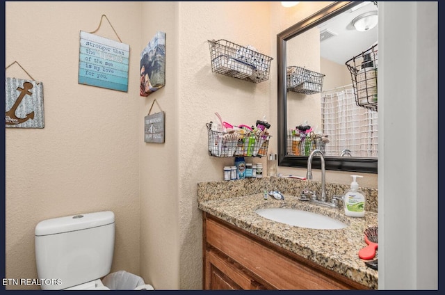 bathroom featuring vanity and toilet