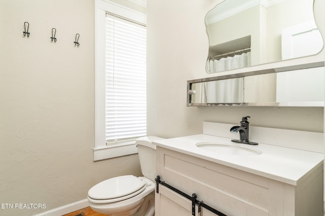 bathroom featuring vanity, toilet, and ornamental molding