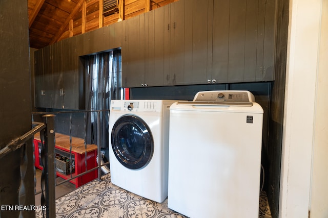 laundry area with washer and dryer and wooden walls