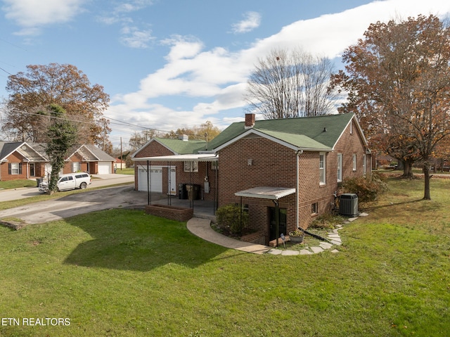 view of side of home featuring a lawn, a garage, and central AC