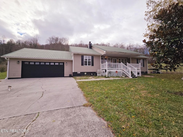 view of front of house featuring covered porch, a front yard, and a garage