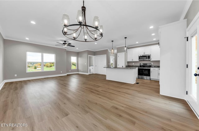 kitchen with stainless steel appliances, crown molding, light hardwood / wood-style flooring, white cabinets, and hanging light fixtures