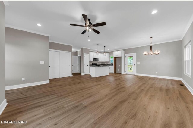 250 Clear Creek Rd, Kodak, TN 37764 - unfurnished living room with ceiling fan, a chandelier, baseboards, crown molding, and light wood-style floors