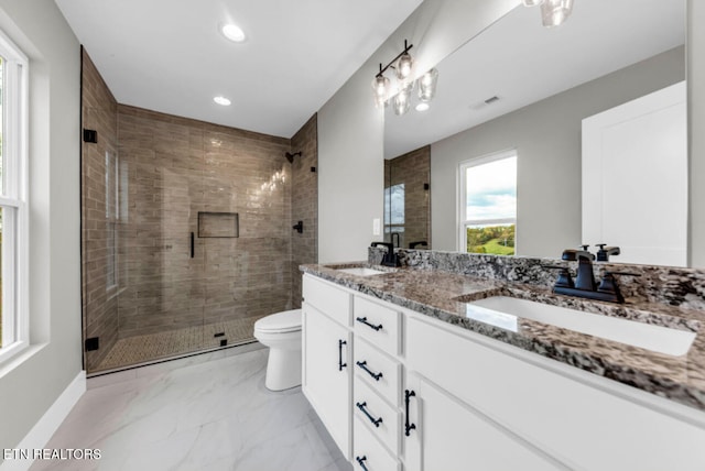 bathroom with vanity, toilet, and a shower with door