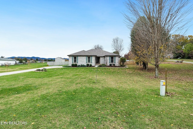 single story home featuring a mountain view and a front lawn