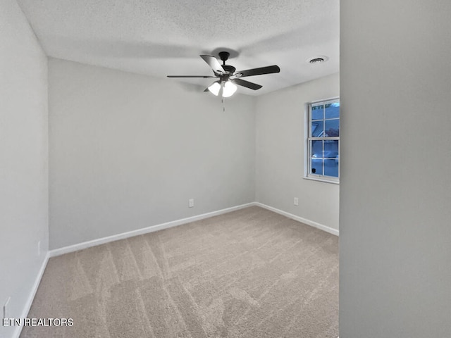 carpeted empty room featuring ceiling fan and a textured ceiling