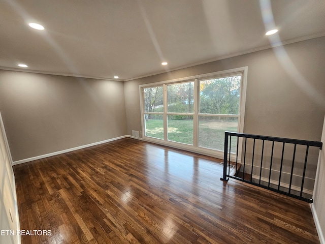 empty room with dark wood-type flooring and crown molding