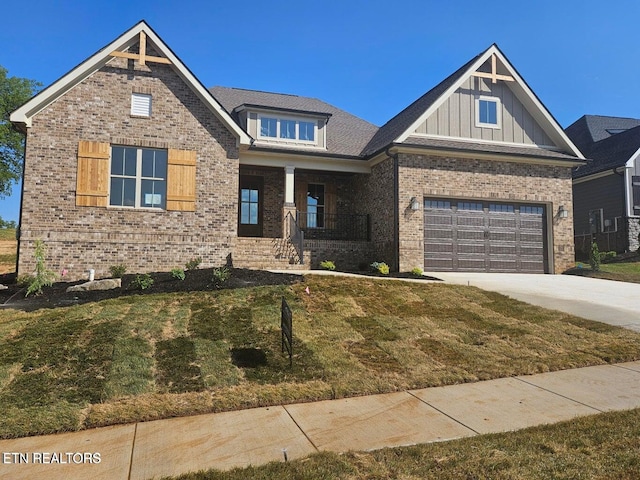 craftsman-style house featuring covered porch, a garage, and a front yard