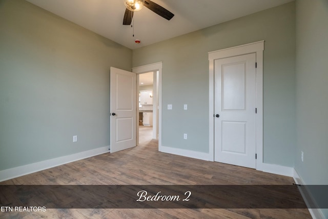 unfurnished bedroom featuring ceiling fan and hardwood / wood-style flooring