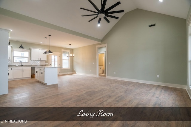 kitchen with light wood-type flooring, decorative light fixtures, white cabinetry, and a kitchen island