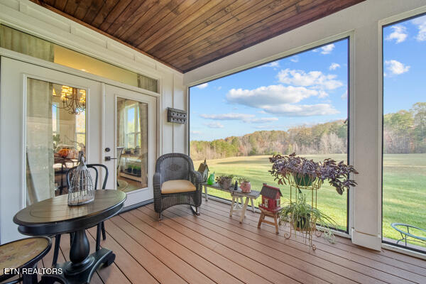 sunroom featuring french doors, plenty of natural light, and wooden ceiling