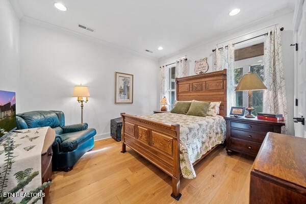 bedroom with light hardwood / wood-style floors and crown molding