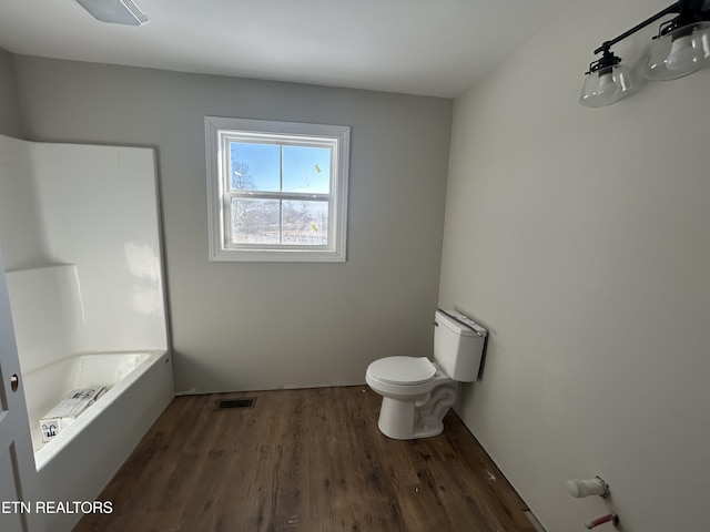 bathroom with hardwood / wood-style floors and toilet