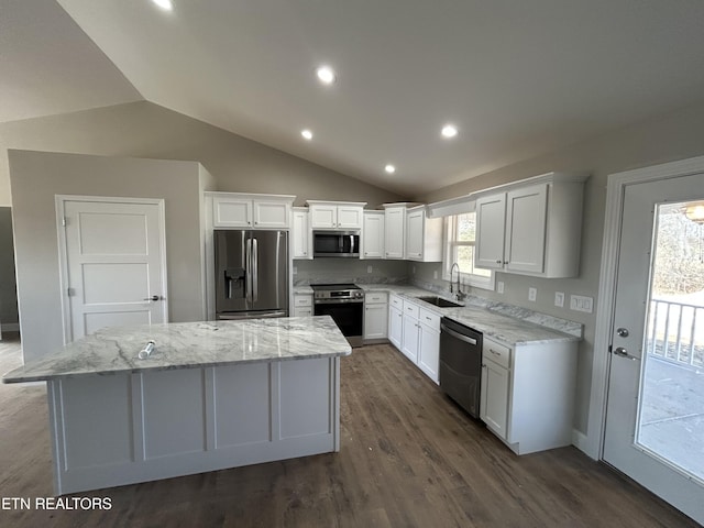 kitchen with dark wood-style flooring, a kitchen island, a sink, white cabinets, and appliances with stainless steel finishes