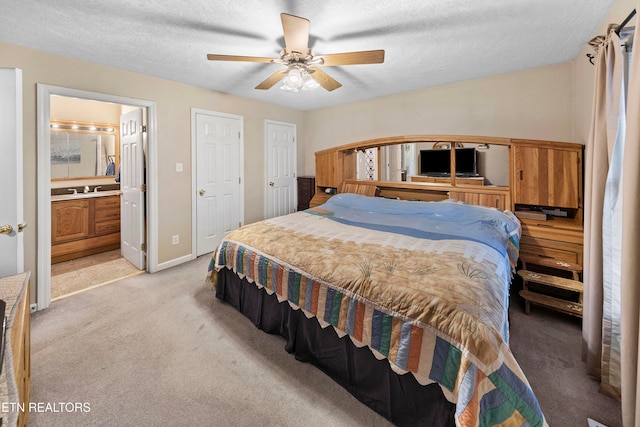 bedroom featuring connected bathroom, ceiling fan, light carpet, and a textured ceiling