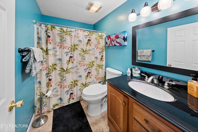 bathroom with vanity, curtained shower, toilet, and a textured ceiling