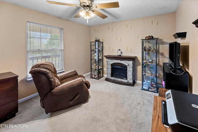 carpeted living room with a textured ceiling, ceiling fan, and a fireplace