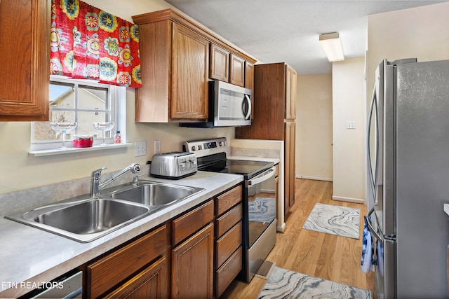 kitchen featuring sink, light hardwood / wood-style floors, and appliances with stainless steel finishes