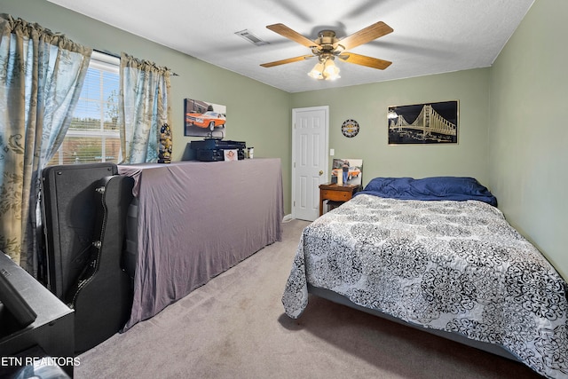 carpeted bedroom with ceiling fan and a textured ceiling