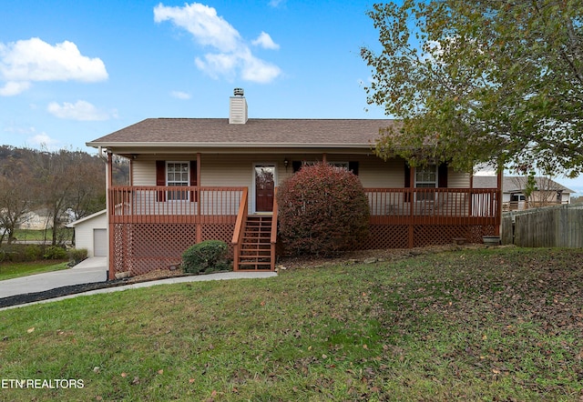 view of front of home with a front yard, a garage, an outdoor structure, and covered porch